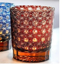 Red cut crystal whisky glass with white geometric web pattern and amber base
