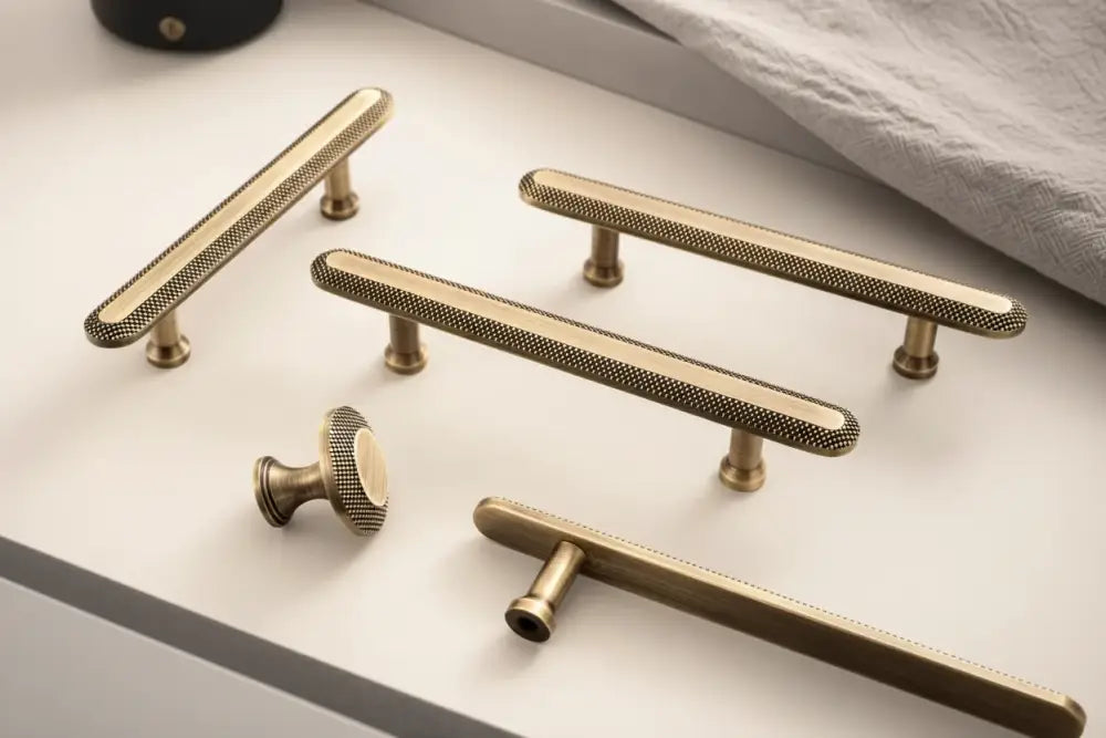 Antique brass cabinet pull with knurled grid grip and round end posts.