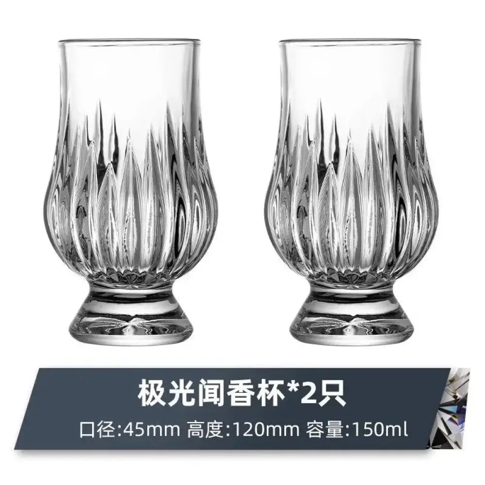 Clear faceted crystal whiskey tasting glass with vertical cut pattern and round foot