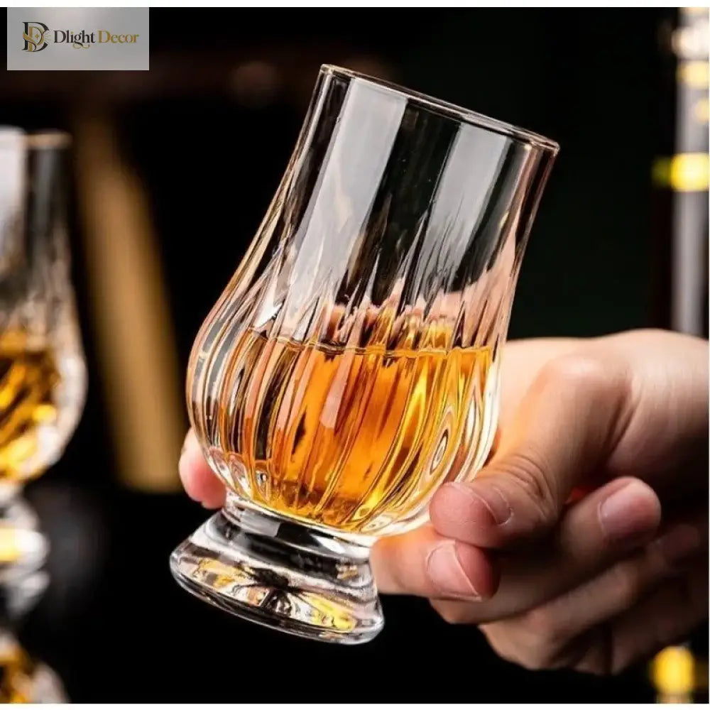 Handheld faceted crystal whiskey tasting glass with amber liquid and cut-glass base