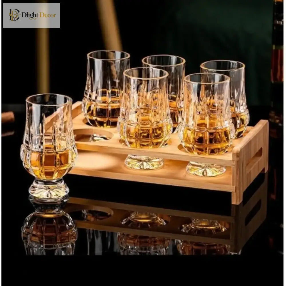 Crystal whiskey tasting glasses on wooden tray, clear cut bowls with amber drink