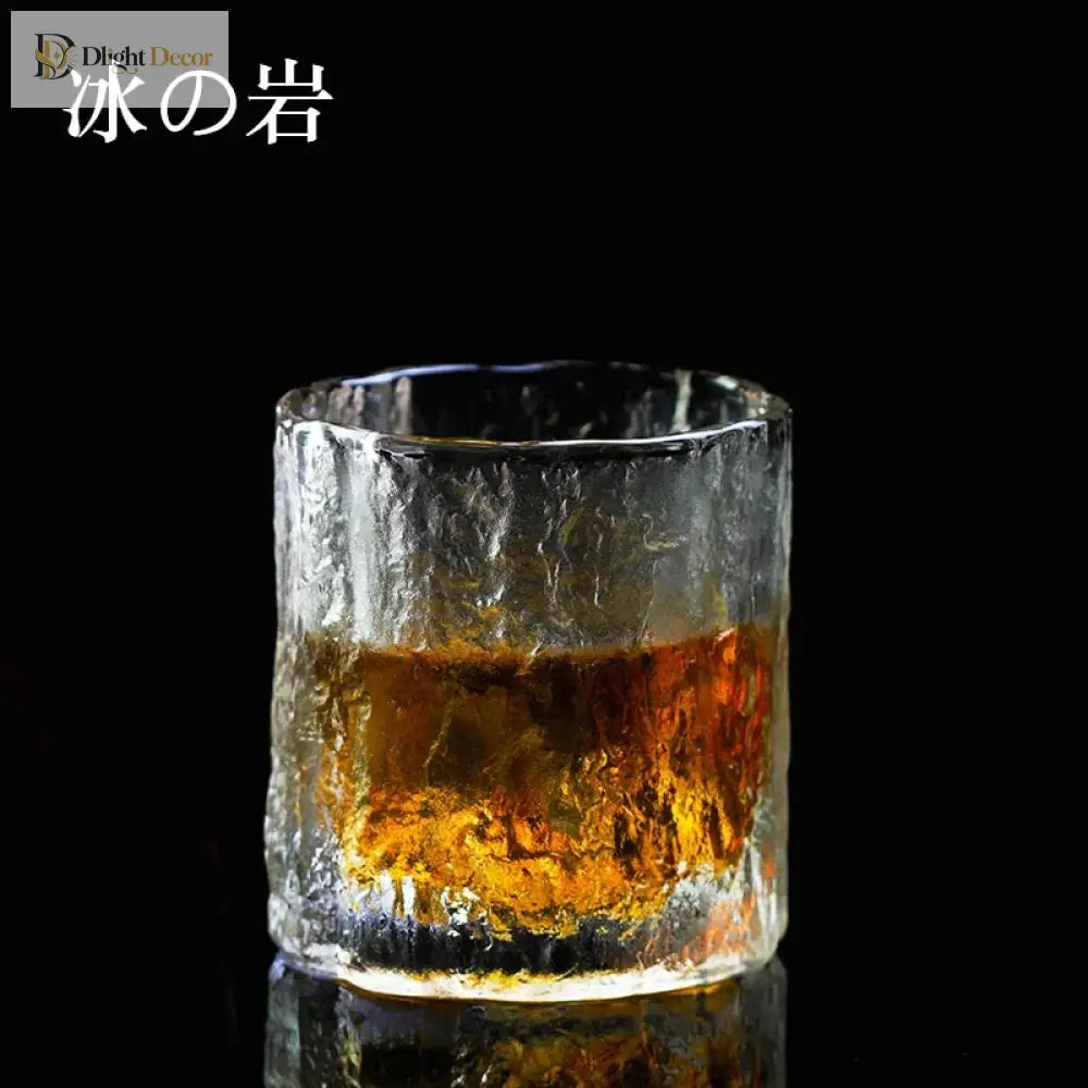 Hammered crystal rocks glass with amber liquid, thick textured rim.