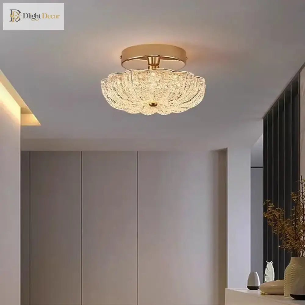 Gold flush-mount ceiling light with clear crystal-style acrylic drum shade