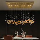 Gold glass pendant chandelier with hanging strands and warm bulbs above dining table