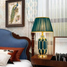 Ceramic LED desk lamp with teal honeycomb base and green pleated shade
