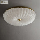 White crystal-style acrylic LED flush-mount ceiling light with scalloped diffuser and brass cap