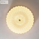 Round scalloped acrylic diffuser for a flush-mount LED ceiling light with brass center