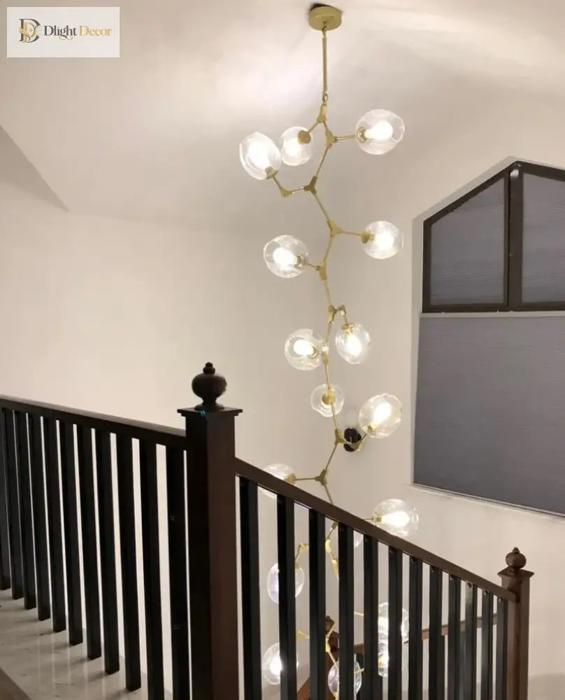 Gold molecular glass chandelier featuring clear globe light heads on a ceiling plate