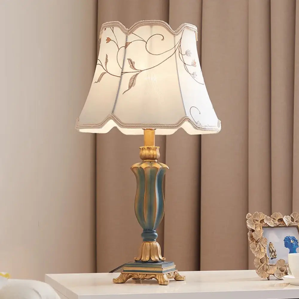 LED desk lamp with cream floral lampshade and teal-blue resin base with gold finials.