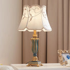LED desk lamp with cream floral lampshade and teal-blue resin base with gold finials.