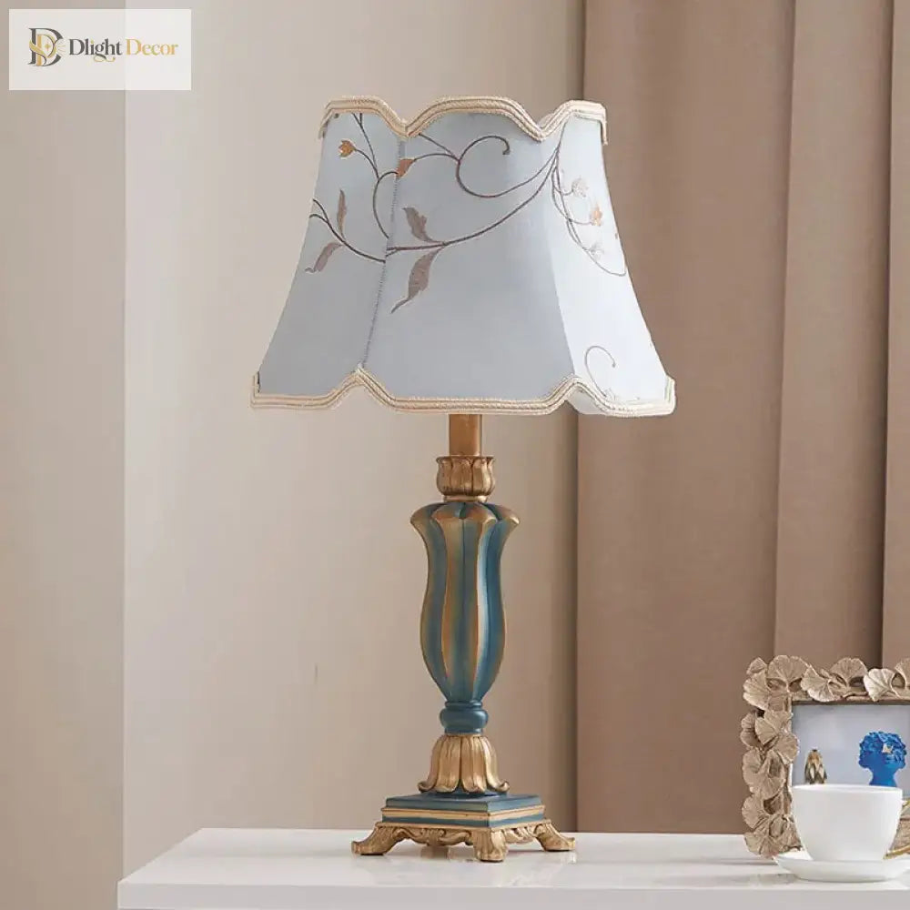 LED desk lamp with cream floral lampshade and teal-blue resin base with gold trim.