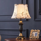 Cream floral fabric lampshade with gold trim on dark resin table lamp base