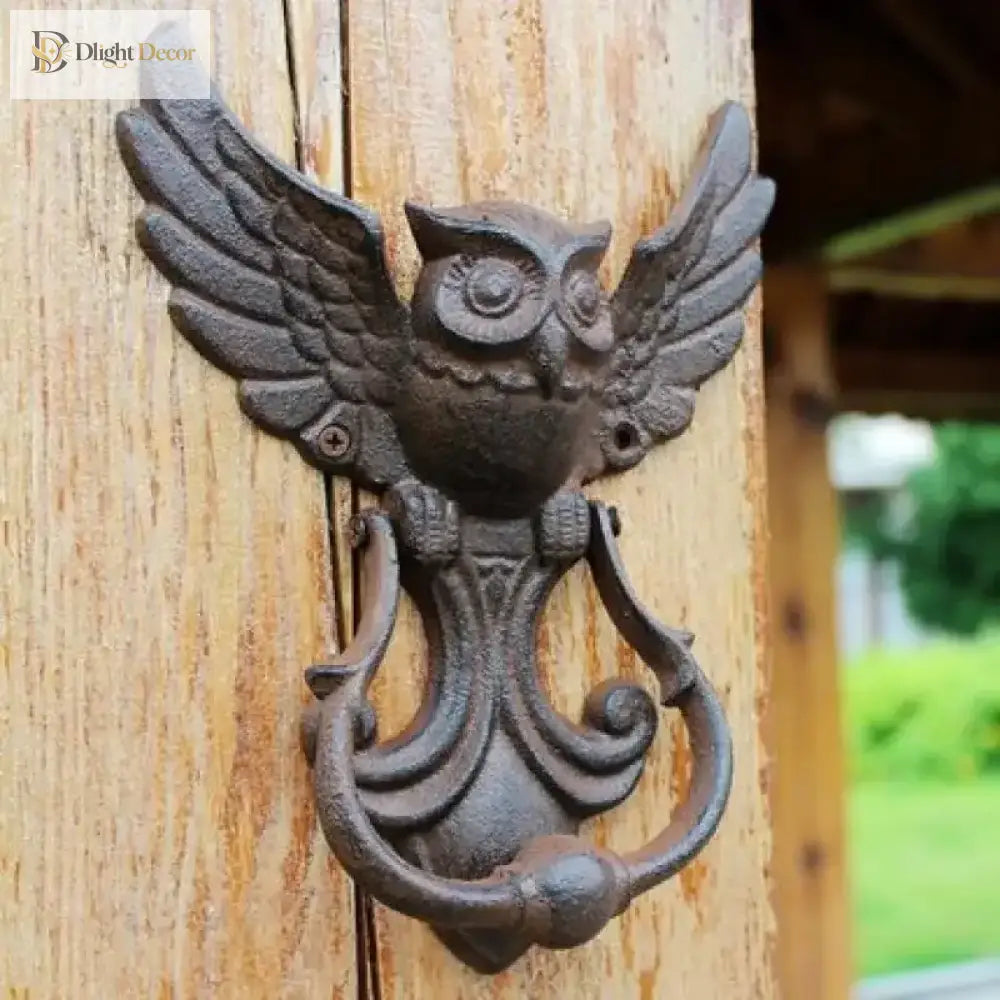 Cast iron owl door knocker with detailed wings and curved handle, shown on a door