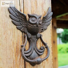 Cast iron owl door knocker with detailed wings and curved handle, shown on a door
