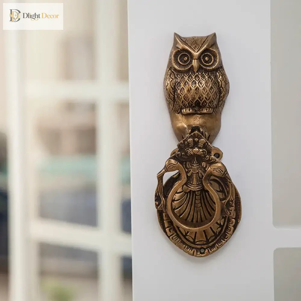 Victorian cast brass owl door knocker on door, front view with ribbed body and carved crest