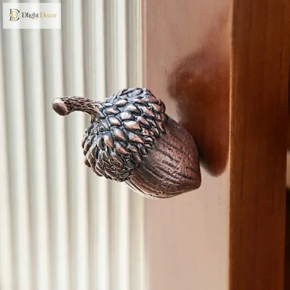 Textured metal acorn knob mounted on a cabinet drawer front