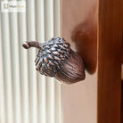 Textured metal acorn knob mounted on a cabinet drawer front