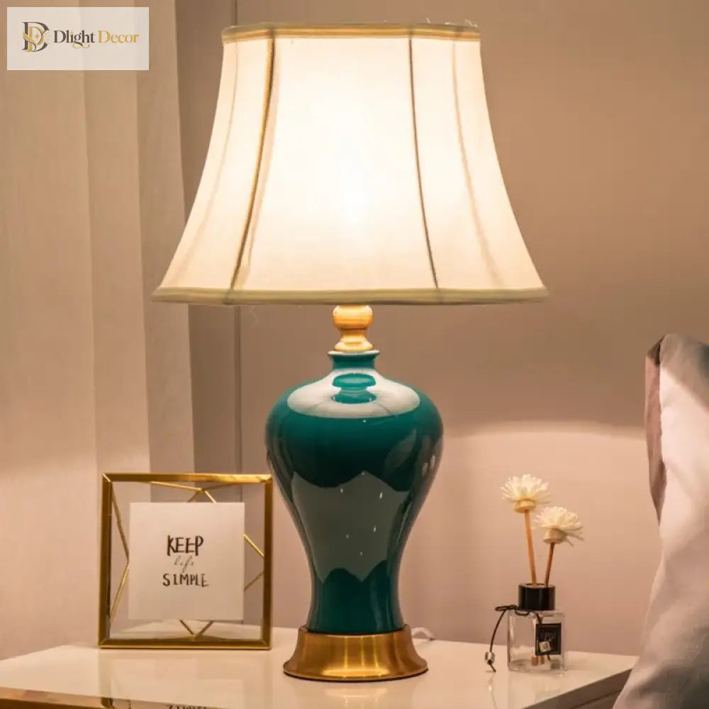 Teal ceramic LED desk lamp with lit pleated shade and gold-trim base