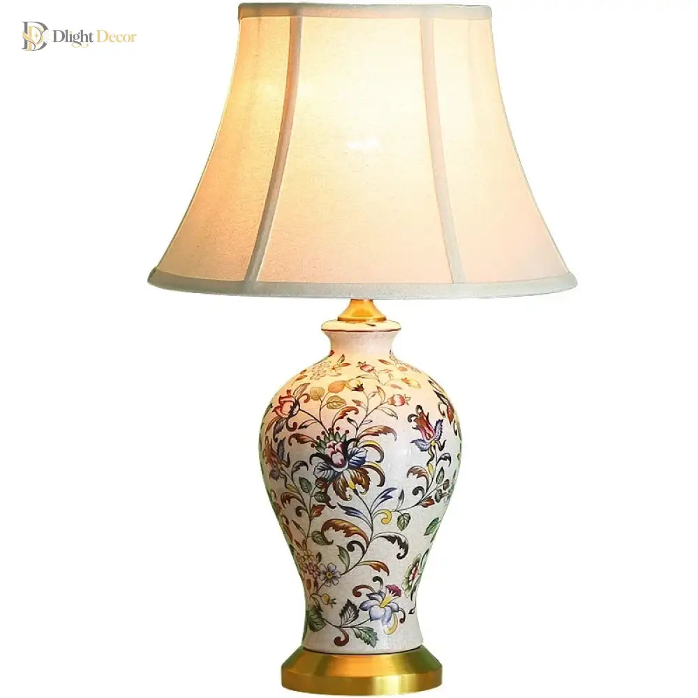 Floral ceramic table lamp featuring a pleated fabric shade and gold-toned base.