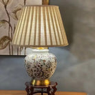 Close view of floral ceramic base and pleated shade on a brass stand