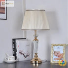 Gold and clear crystal LED table lamp with pleated white fabric shade and column base