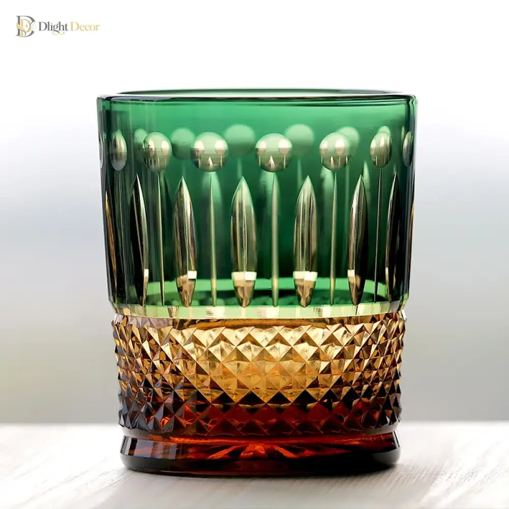 Green diamond-cut crystal whiskey tumbler with gold-toned faceted band and faceted base