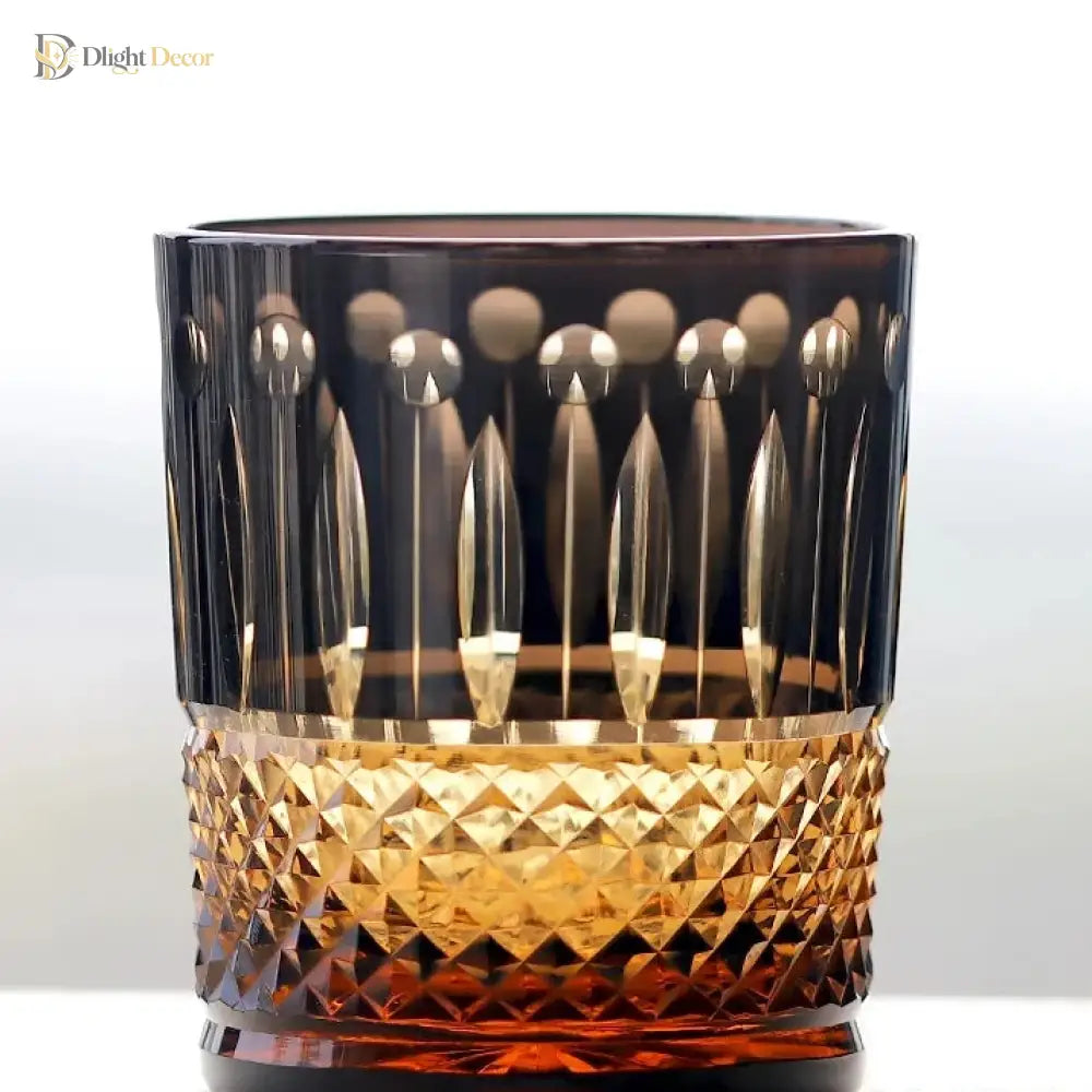 Dark crystal whiskey tumbler with gold-toned diamond-cut band and faceted base