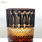 Dark crystal whiskey tumbler with gold-toned diamond-cut band and faceted base