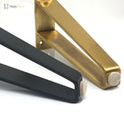 Detail view of U-shaped metal furniture leg bases with end caps, gold and black