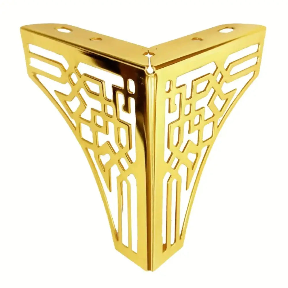 Gold-tone geometric metal furniture leg with cutout lattice design, corner view