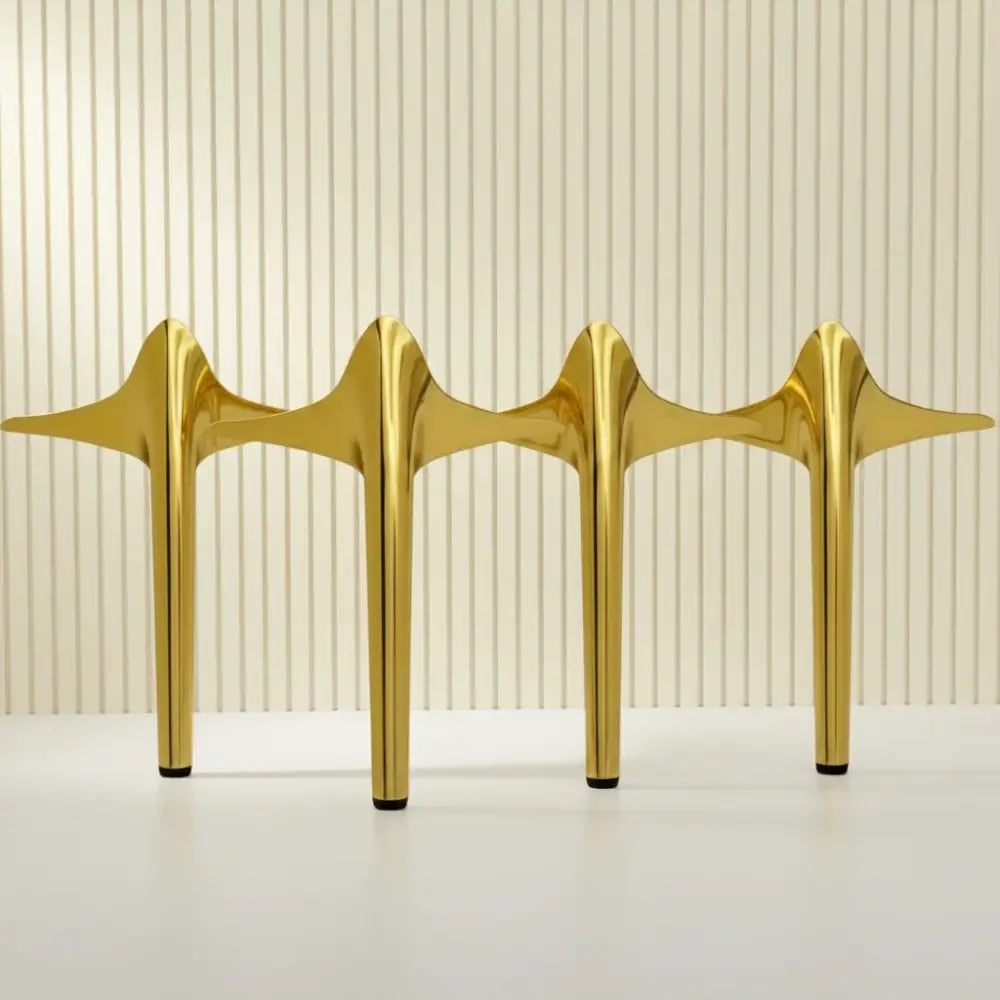 Four gold stainless steel furniture legs with rubber protectors, tapered spade-style bases