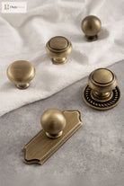 Set of single-hole cabinet handles with round knobs and decorative circular backplates, solid brass