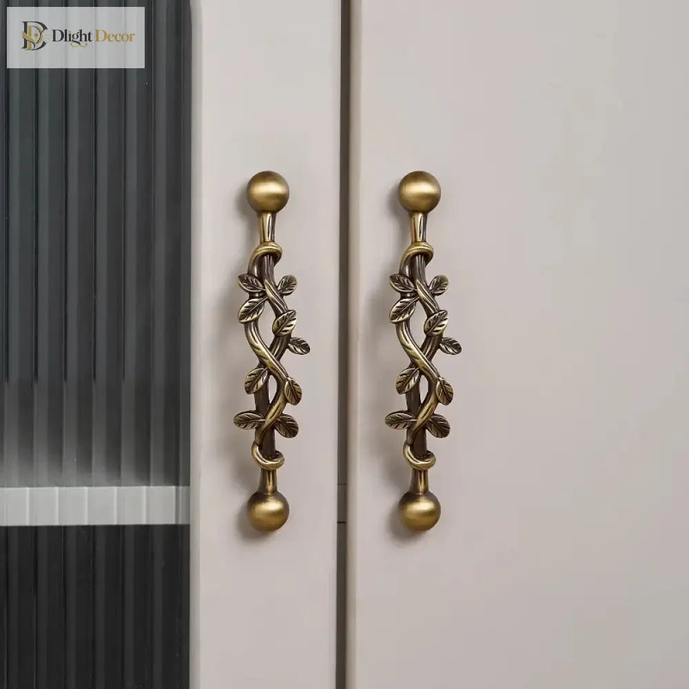 Antique bronze vine wardrobe pulls with two round knobs on a door panel