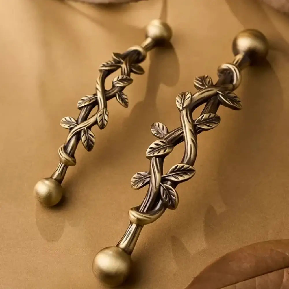 Antique bronze vine cabinet pull handle with two round knobs and leaf scroll detail