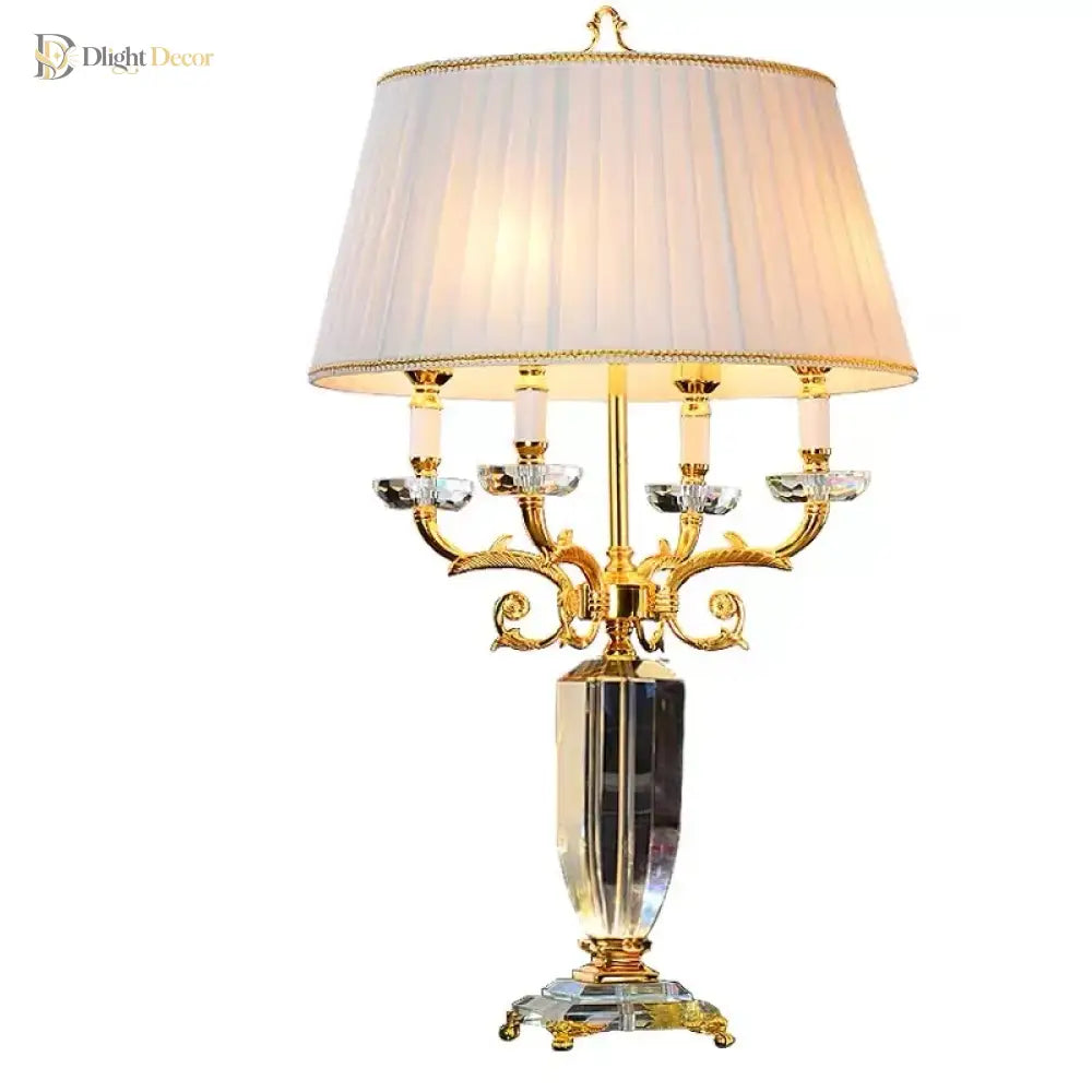 Gold crystal table lamp with pleated white drum shade and curved candelabra arms.