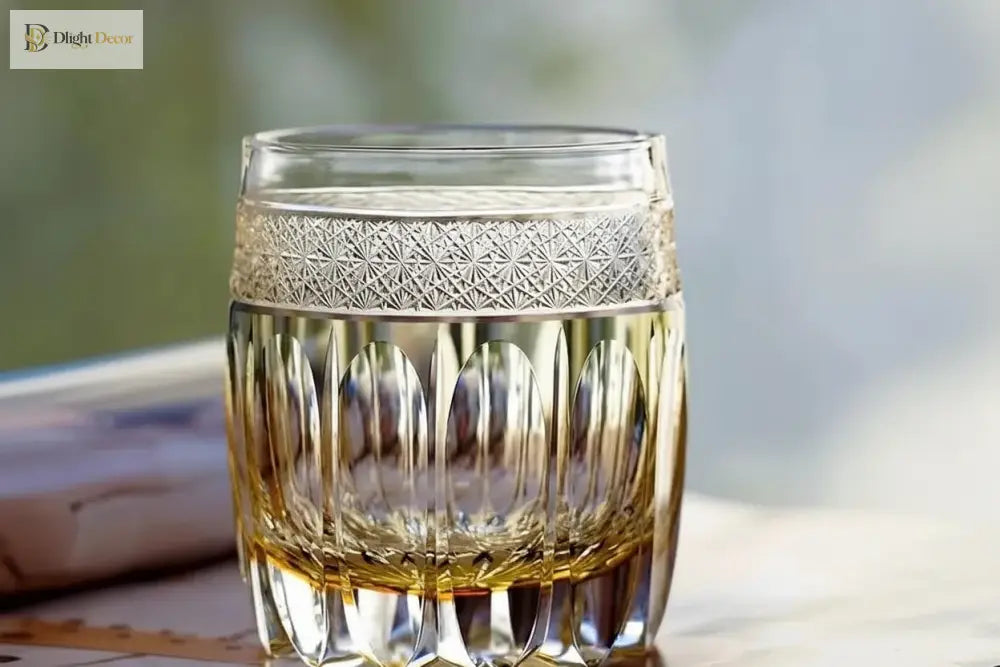 Amber crystal whiskey tumbler with geometric cut band and faceted sides